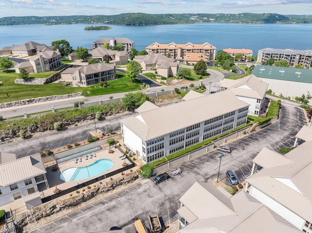 drone / aerial view of a pool area and a nearby body of water