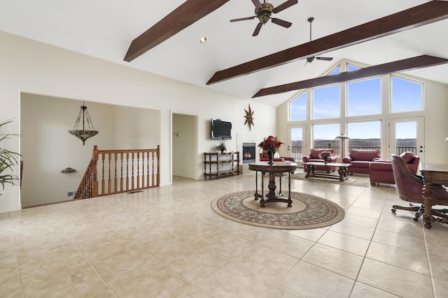 living room featuring a ceiling fan, beamed ceiling, high vaulted ceiling, and tile patterned floors