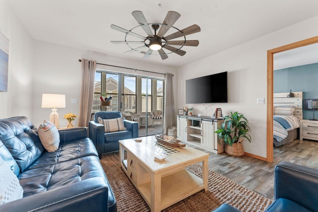 living area with light wood-type flooring, a ceiling fan, and baseboards