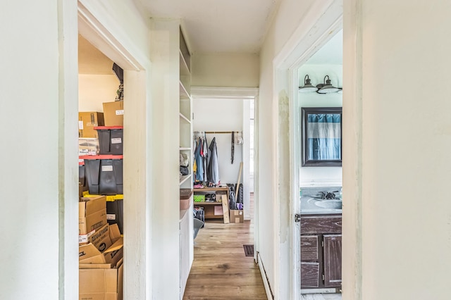 hallway with wood finished floors and a sink