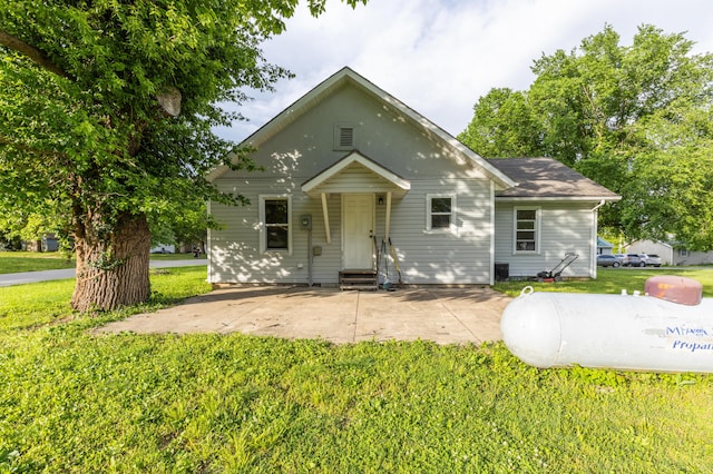 bungalow-style house with a front yard, a patio area, and entry steps