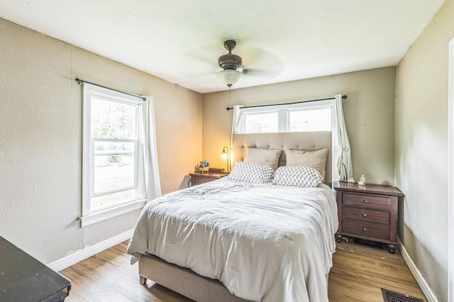 bedroom featuring wood finished floors, baseboards, and a ceiling fan