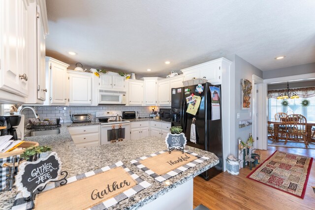 522 E Grace St, Republic, MO 65738 - kitchen featuring black appliances, a sink, wood finished floors, decorative backsplash, and white cabinets