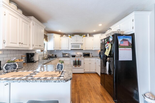 522 E Grace St, Republic, MO 65738 - kitchen with white appliances, a sink, a peninsula, light wood-style floors, and tasteful backsplash