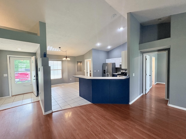 707 S Eastridge, Nixa, MO 65714 - kitchen with appliances with stainless steel finishes, light wood finished floors, a peninsula, white cabinets, and vaulted ceiling