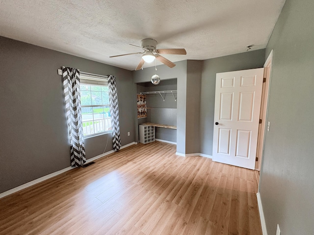 707 S Eastridge, Nixa, MO 65714 - unfurnished bedroom featuring wood finished floors, baseboards, a closet, a textured ceiling, and a ceiling fan
