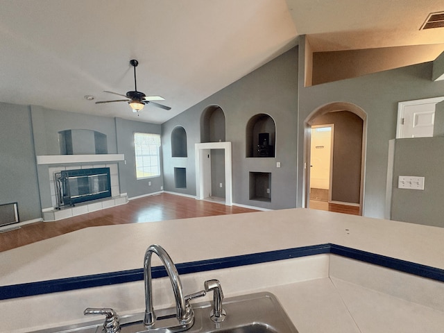 707 S Eastridge, Nixa, MO 65714 - kitchen with a fireplace, ceiling fan, lofted ceiling, wood finished floors, and light countertops