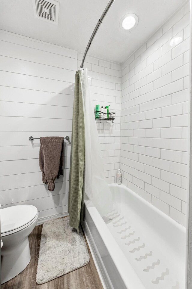 2221 W Nichols St, Springfield, MO 65802 - bathroom featuring wood finished floors, toilet, and shower / tub combo