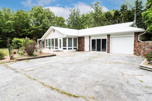 358 High Ridge Rd, Marshfield, MO 65706 - back of house featuring an attached garage, brick siding, asphalt driveway, and metal roof