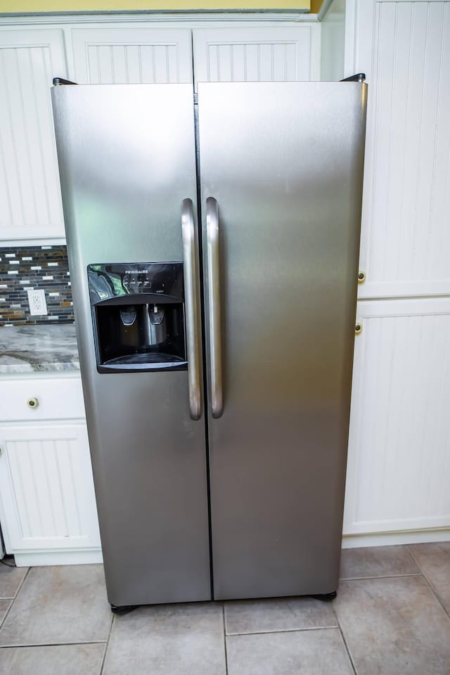 358 High Ridge Rd, Marshfield, MO 65706 - kitchen view of stainless steel fridge, light stone counters, tasteful backsplash, and white cabinetry