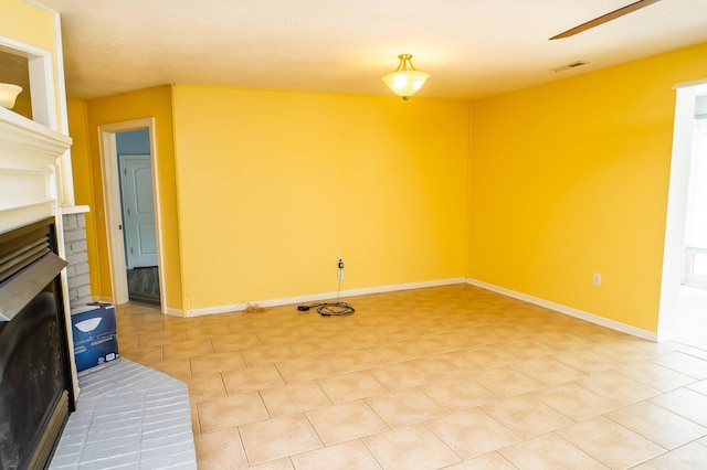 358 High Ridge Rd, Marshfield, MO 65706 - unfurnished living room featuring a brick fireplace, light tile patterned floors, baseboards, and ceiling fan