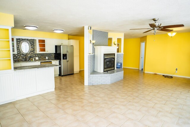 358 High Ridge Rd, Marshfield, MO 65706 - kitchen featuring stainless steel refrigerator with ice dispenser, a ceiling fan, white cabinets, backsplash, and baseboards