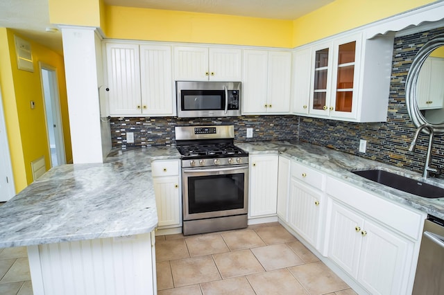 358 High Ridge Rd, Marshfield, MO 65706 - kitchen featuring stainless steel appliances, a peninsula, a sink, backsplash, and light tile patterned floors