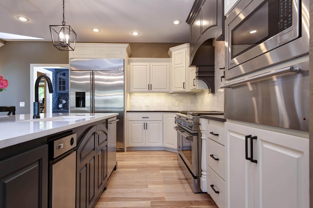 5853 S Northern Ridge Rd, Springfield, MO 65810 - kitchen with built in appliances, white cabinetry, light wood-type flooring, pendant lighting, and recessed lighting