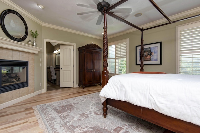 5853 S Northern Ridge Rd, Springfield, MO 65810 - bedroom featuring light wood-type flooring, a tiled fireplace, ornamental molding, baseboards, and ceiling fan