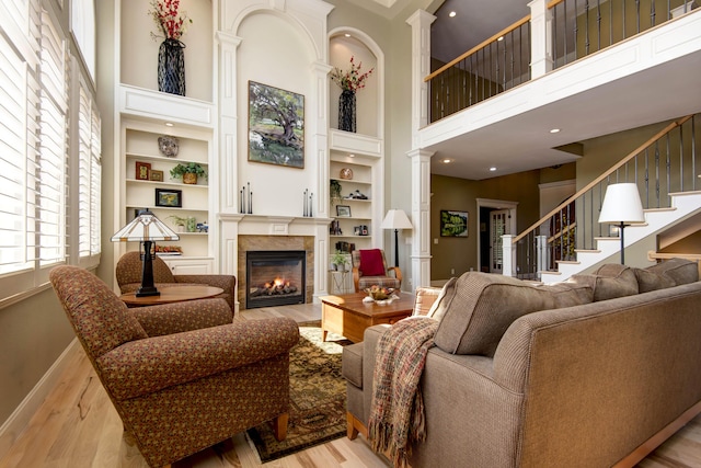 5853 S Northern Ridge Rd, Springfield, MO 65810 - living area featuring a towering ceiling, decorative columns, a lit fireplace, wood finished floors, and built in features