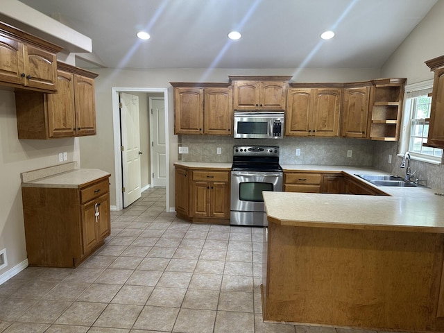 kitchen featuring appliances with stainless steel finishes, a sink, tasteful backsplash, light countertops, and recessed lighting
