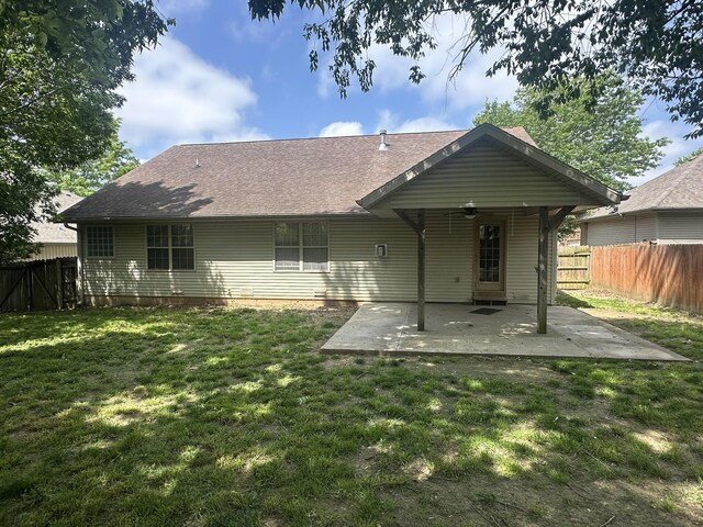 rear view of house with a patio area and roof with shingles
