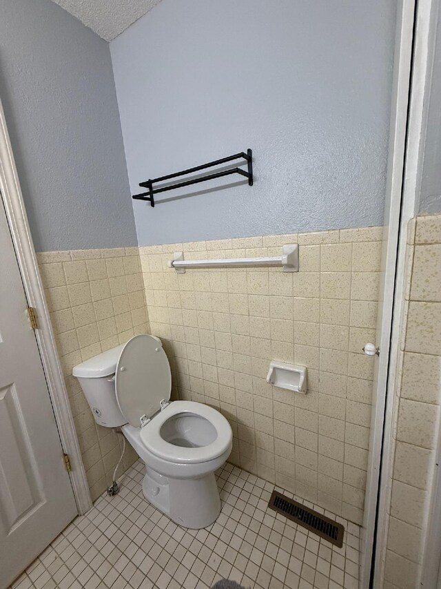 3036 P Hwy, Alton, MO 65606 - bathroom with toilet, tile walls, tile patterned flooring, wainscoting, and a textured wall