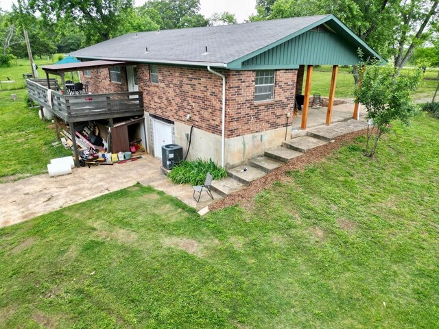 3036 P Hwy, Alton, MO 65606 - back of property featuring brick siding, a yard, a shingled roof, a garage, and a patio