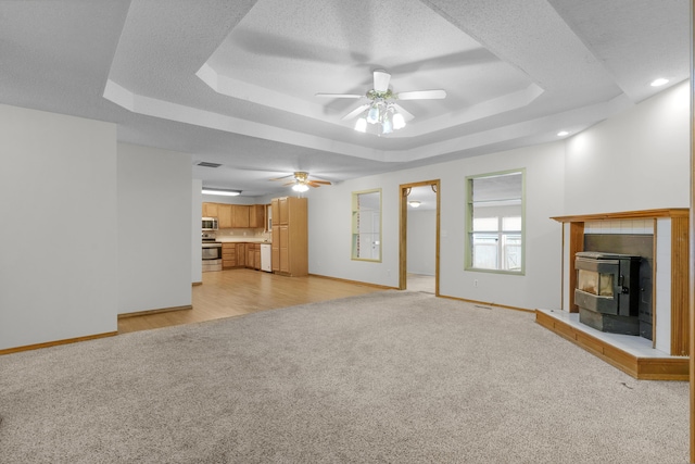 3563 S Western Ave, Springfield, MO 65807 - unfurnished living room with light colored carpet, a tray ceiling, ceiling fan, and baseboards