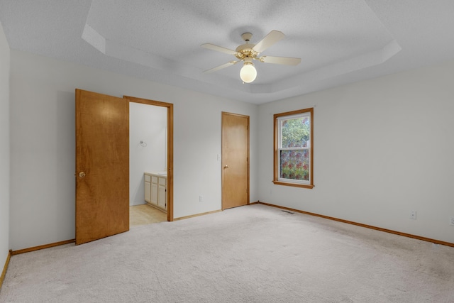 3563 S Western Ave, Springfield, MO 65807 - unfurnished bedroom with a raised ceiling, light colored carpet, baseboards, a textured ceiling, and ensuite bathroom