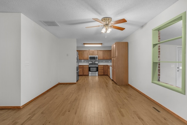 3563 S Western Ave, Springfield, MO 65807 - kitchen featuring appliances with stainless steel finishes, light wood finished floors, baseboards, ceiling fan, and a textured ceiling