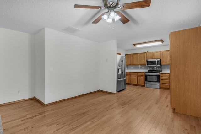 3563 S Western Ave, Springfield, MO 65807 - kitchen with stainless steel appliances, light wood-style flooring, ceiling fan, light countertops, and brown cabinetry