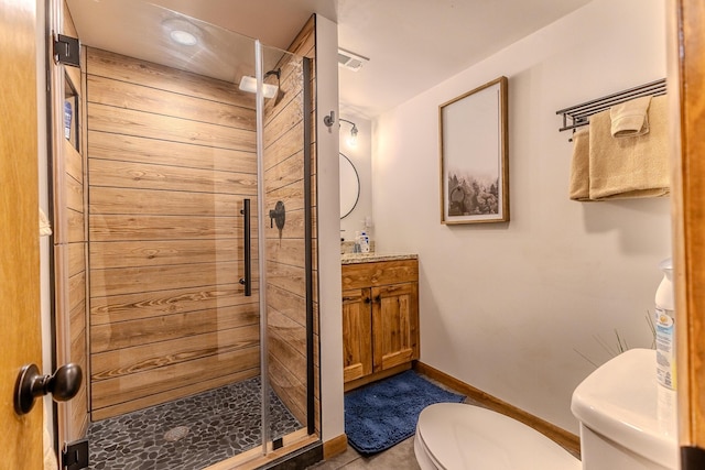 full bathroom with toilet, a shower stall, vanity, and baseboards