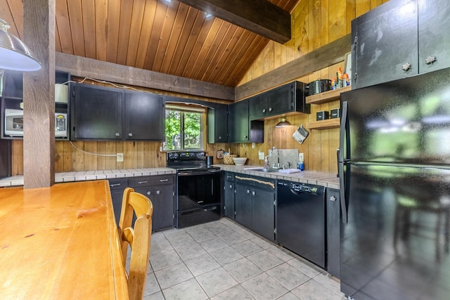 kitchen featuring black appliances, a sink, tile countertops, open shelves, and wooden walls