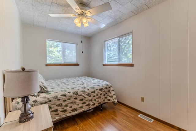 bedroom with wood finished floors, ceiling fan, and baseboards