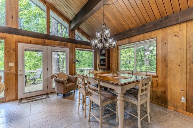dining space featuring wood walls, a chandelier, light tile patterned floors, and wooden ceiling