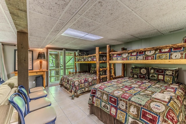 bedroom featuring tile patterned flooring and a drop ceiling