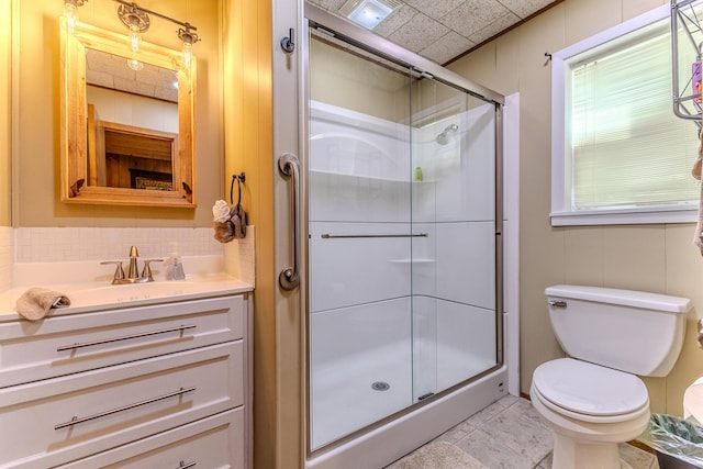 bathroom featuring a shower stall, toilet, tasteful backsplash, and vanity