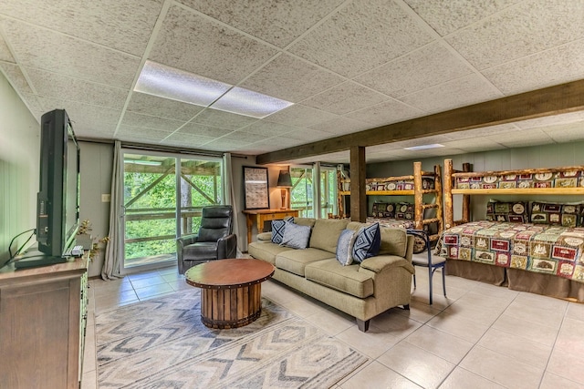living room featuring tile patterned flooring and a drop ceiling