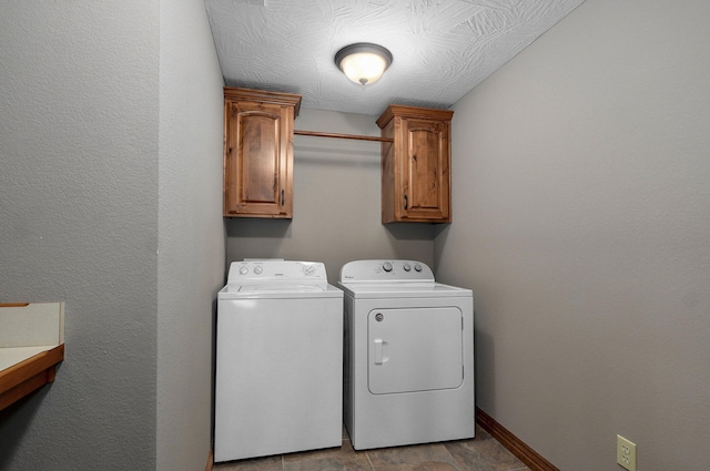 laundry room featuring washing machine and dryer, cabinet space, and baseboards