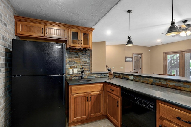 kitchen with black appliances, dark countertops, and brown cabinetry