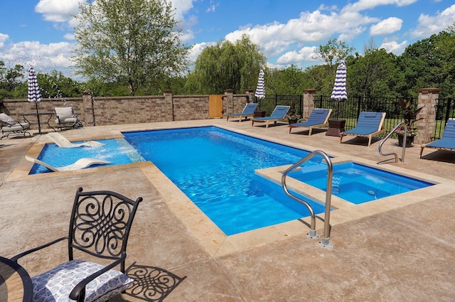 view of pool featuring a patio, a pool with connected hot tub, and fence