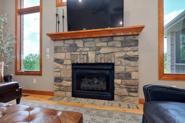 detailed view of wood finished floors, baseboards, and a fireplace