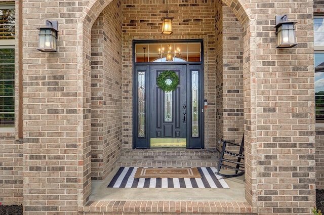 doorway to property featuring brick siding