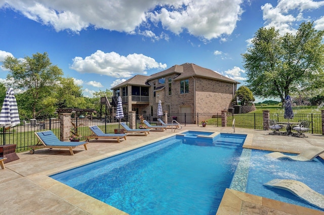 view of pool with a patio area, fence, and a pool with connected hot tub