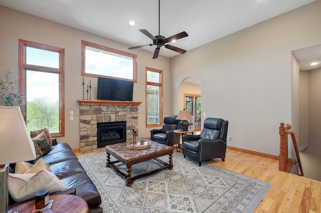 living room with wood-type flooring, recessed lighting, ceiling fan, arched walkways, and baseboards