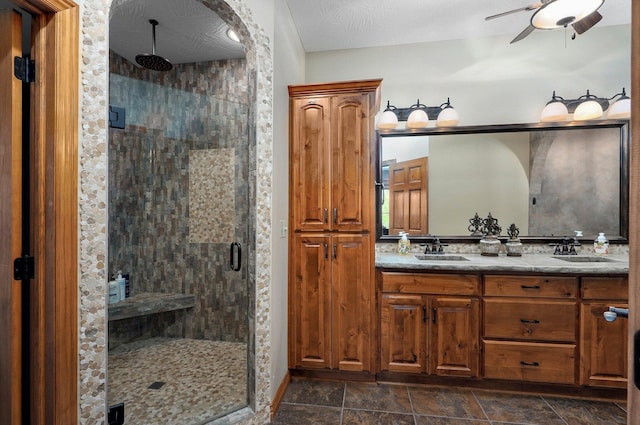 bathroom featuring a shower stall, ceiling fan, and double vanity