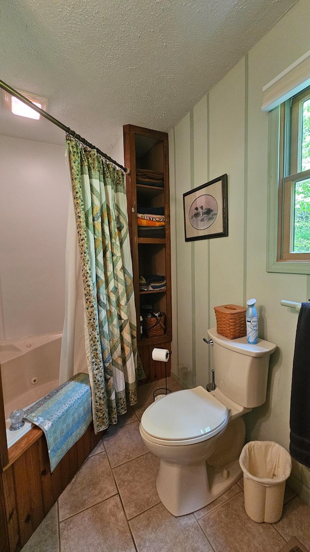 full bath with toilet, a textured ceiling, and tile patterned flooring