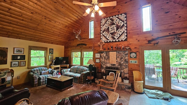 living area with high vaulted ceiling, a ceiling fan, a stone fireplace, and wooden ceiling