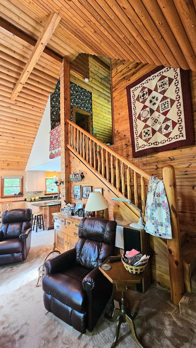 carpeted living room featuring wooden ceiling, high vaulted ceiling, wood walls, and beam ceiling