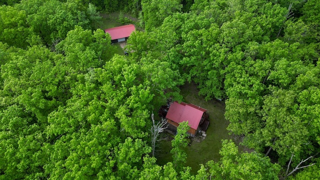 aerial view of property and surrounding area featuring a heavily wooded area