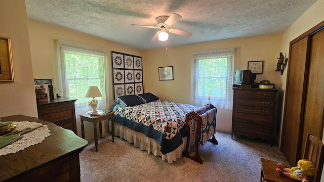 bedroom featuring a textured ceiling, carpet, a ceiling fan, and a closet