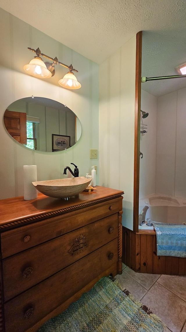 bathroom featuring vanity, a textured ceiling, shower / bathtub combination, and tile patterned flooring