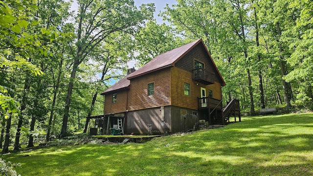 view of home's exterior featuring stairway, a yard, a chimney, and a deck